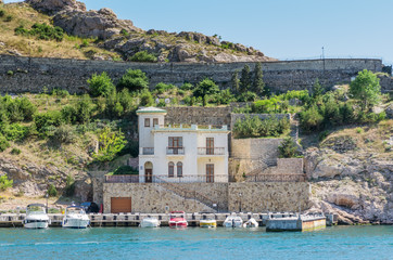 Fototapeta premium Pier in the sea bay. Russia, Republic of Crimea, Balaclava. 11.06.2018: Pleasure boats in Balaklavskl Bay