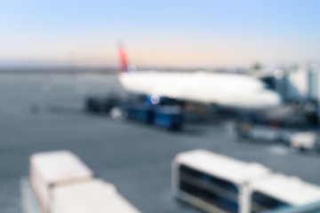Fototapeta premium Airplane at airport terminal boarding gate. Blurred out of focus.