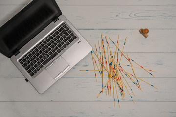 Table with laptop. Mikado game and a stamp
