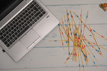 Table with laptop. Mikado game and a stamp