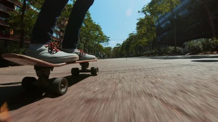 Low perspective shot of male feet in sneakers or skating shoes ride longboard and swerve on pavement. Cool extreme sport lifestyle or transportation mode for busy city life, always on move lifestyle - Powered by Adobe