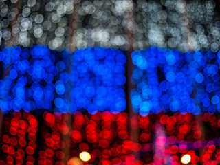 The lights blurred bokeh background in colors of the Russian flag. white, red and blue