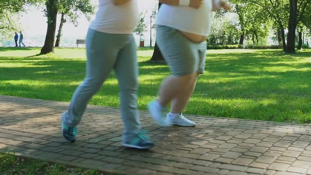 Overweight couple running together in morning supporting each other, dieting