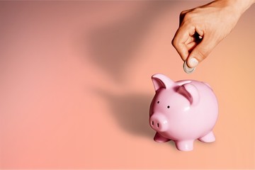 Hand putting coin to piggy bank