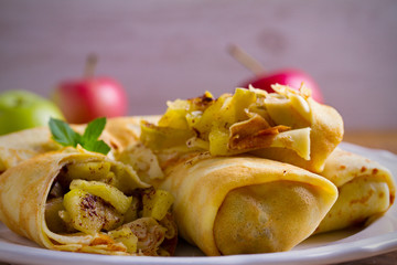 Delicious homemade crepes filled with apples and cinnamon. horizontal
