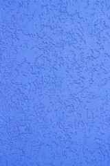 Decorative plaster on the wall, painted in a blue color_