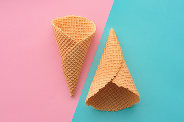 Ice cream waffle cones on pastel pink and blue background