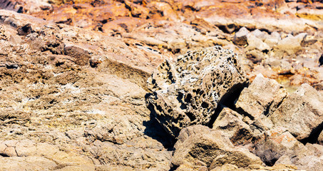 View of the rocks on the beach Papakolea (green sand beach), Hawaii, USA. With selective focus.