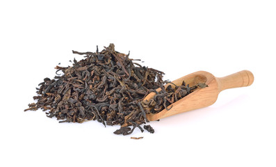 Wooden scoop with black tea with leaf isolated on white