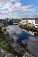 Fototapeta premium Clouds and sky reflected in a river of a small Irish village