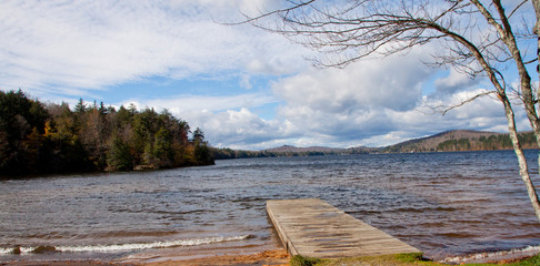 Choppy Lake, leafless tree, empty dock, cloudy sky