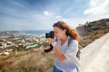 Beautiful young woman with a camera in hand, traveler and bloggen on the background of a beautiful...