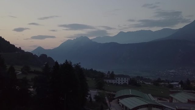Aerial view of Levico Terme, Italy during sunrise with drone flying forward