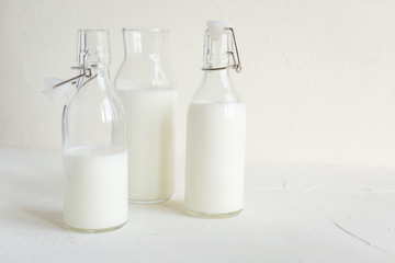 Milk in bottles on white background, kitchen
