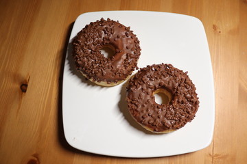 ring chocolate covered doughnuts on a white plate