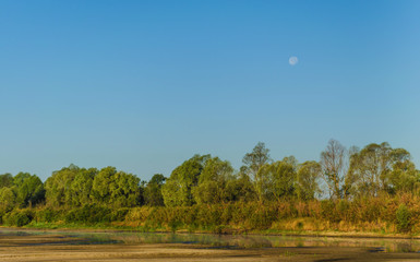 Dawn with fog after night in the morning against the backdrop of the moon and nature. Belarusian Polesie. Pripyat