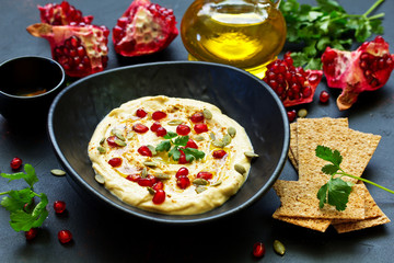Traditional hummus, with pomegranate and cereal loaves. selective focus.