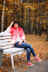 Girl on a bench in the autumn park.