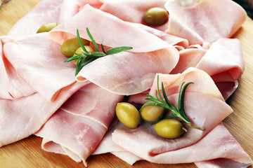 Sliced ham on wooden background. Fresh prosciutto. Pork ham sliced.