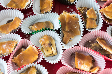Close up view of homemade Christmas Crack, a toffee, chocolate and salted caramel candy, individually packaged in paper wrappers