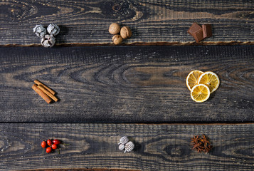 Top view, flat lay. Christmas composition made of cinnamon sticks, cones, oranges, rosehip fruits, anise and almonds on wooden background