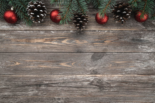 Old wood background with fir branches adorned with baubles and cones. Space for text. Christmas card. Top view. Xmas.