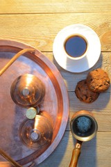 a biscuits and a Cup of coffee near the sugar bowl and container with coffee on rustic wooden table