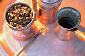 close up coffee beans to in a copper container on a dark background
