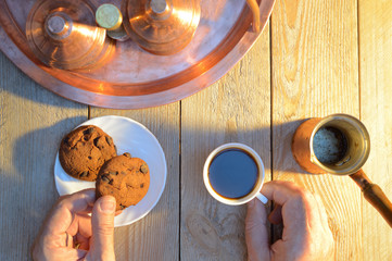 hands take coffee and biscuits from wooden rustic
