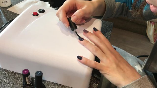 girl paints nails at home. manicure