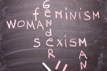Words gender, sexism, feminism written in pink chalk