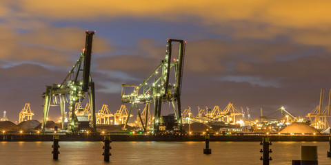 Industrial harbor landscape with  two loading cranes at night