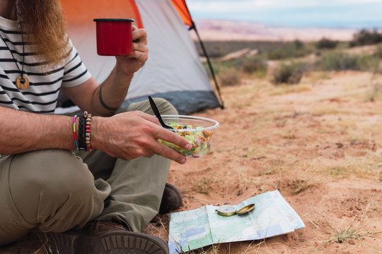 Crop traveler eating near map and compass