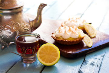 Meyer Lemon Tartlets with Lemon Curd and silver teapot, traditional arabic tea in pot and cup 