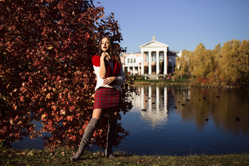 Obraz premium Pretty woman is wearing fashion clothes in autumn park