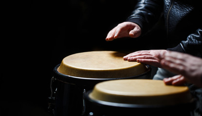 Drum. Hands of a musician playing on bongs. The musician plays the bongo. Close up of musician hand playing bongos drums. Afro-Cuba, rum, drummer, fingers, hand, hit.