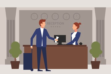 Young man giving reservation to woman receptionist that stands at reception desk.