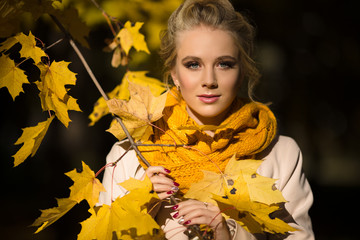 Naklejka na ściany i meble Pretty blonde girl in yellow autumn leaves