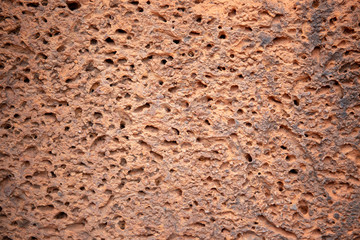 Ancient sandstone masonry, weathered rough surface closeup photo. Porous texture of natural stone