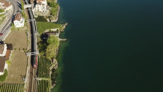Aerial top down view of Swiss train passing along the shore of Lake L&radic;&copy;man in Lavaux vineyard
