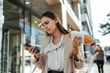 The busy businesswoman working online on a smartphone during a break