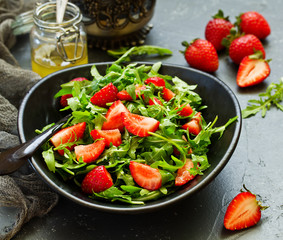 Fresh salad with arugula, strawberries and almonds. Selective focus.