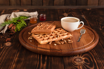 Tasty fresh Vienna wafers, jam and cup of coffee on a dark wooden background