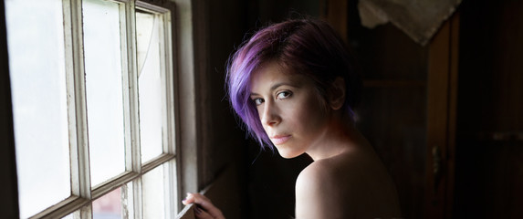 Woman With Purple Hair Looking Out Old Window Buy This Stock