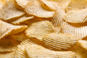 Close up Crispy potatoes chips isolated on white background top view. Food background. 