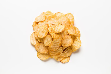 Crispy potatoes chips isolated on white background. Food background. Round pile potato chips on a white table.