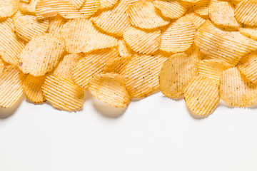 Crispy potatoes chips isolated on white background. Food background.