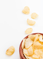 Crispy potatoes chips in wooden bowl isolated on white background. Food background.