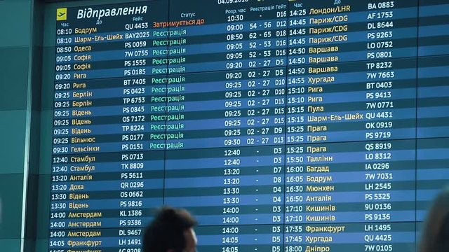 Passengers looking at timetable board screen at the airport, international flight, business man travels abroad