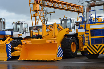 Obraz premium A large yellow excavator bucket. Construction machinery for sand transport. Dump truck for transportation of rock mass and minerals. Special equipment. Mining, career
